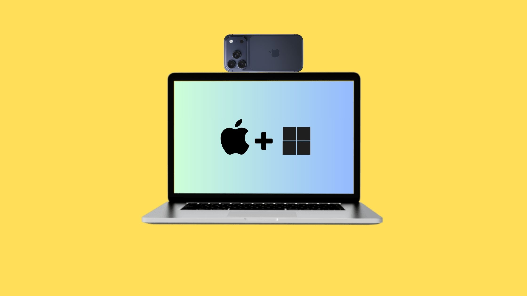An iPhone mounted on top of a MacBook showing Apple and Windows logos on a yellow background